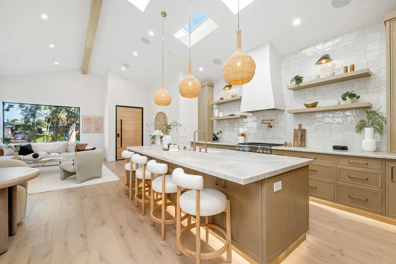 Bright spacious kitchen remodel showing a large island and pendant lights.