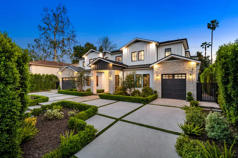 Modern farmhouse exterior painting with white siding and stone accents at dusk. Modern farmhouse exterior painting with white siding and stone accents at dusk.