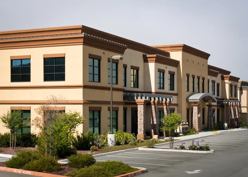 Commercial building exterior painting with neutral tan and brown tones.