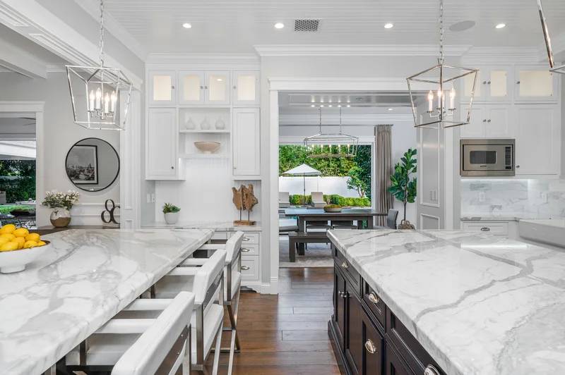 Modern white kitchen remodel with marble island countertops and wood floors. Modern white kitchen remodel with marble island countertops and wood floors.