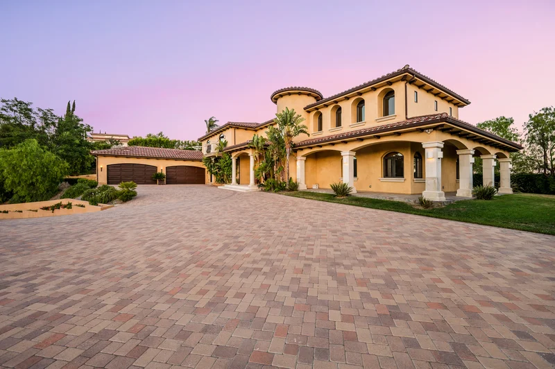 Mediterranean villa exterior paint job with paved driveway at sunset. Mediterranean villa exterior paint job with paved driveway at sunset.